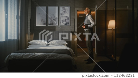 Elegant Mature Hotel Manager in Formal Suit Inspects Luxury Hotel Room 132468251