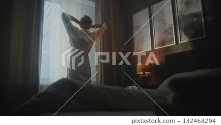 Man Welcomes New Day in Modern Hotel Room Man Welcomes New Day in Modern Hotel Room 132468294