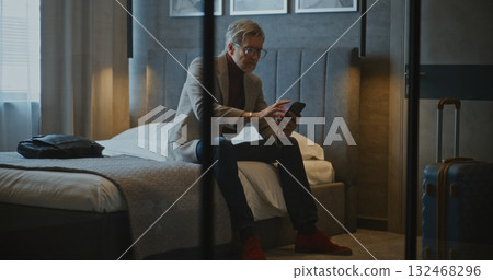 Elegant Mature Businessman Enters Hotel Room After Long Trip 132468296
