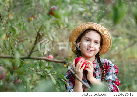 Beautiful girl apple in organic apples in orchard. Girl eating organic apple in garden. 132468515