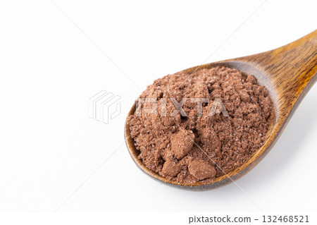 Close-up of cocoa powder with sugar on a spoon on a white background 132468521