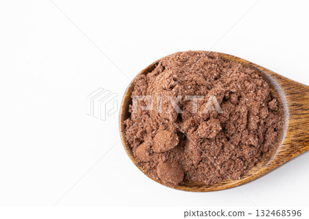 Close-up of cocoa powder with sugar on a spoon on a white background 132468596