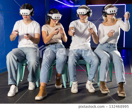 Friends playing video games in virtual reality headsets Friends playing video games in virtual reality headsets 132468995