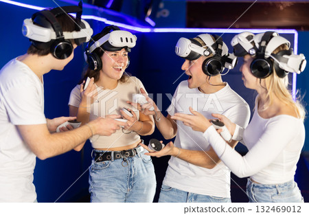 Group of friends chat animatedly after playing virtual reality 132469012