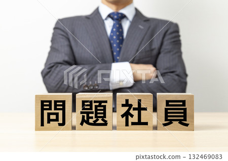 A businessman with his arms crossed and a block that reads "Problem Employee" A businessman with his arms crossed and a block that reads "Problem Employee" 132469083