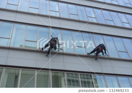 Workers cleaning windows in a high-rise building 132469233