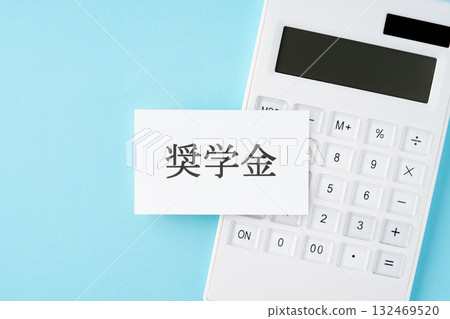 Scholarship lettering and calculator on a light blue background Scholarship lettering and calculator on a light blue background 132469520