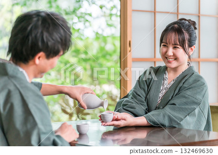 Men and women in yukata serving drinks in a Japanese-style room at a ryokan, married couple, couple 132469630