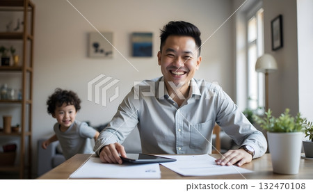 Joyful Father Working at Home with Child Playing in Background During Daytime Joyful Father Working at Home with Child Playing in Background During Daytime 132470108