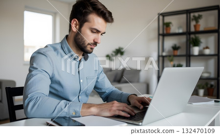 Young Professional Working on Laptop in Modern Office Space with Green Plants Young Professional Working on Laptop in Modern Office Space with Green Plants 132470109