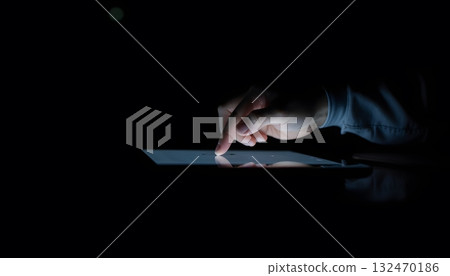 Hand Interacting with Tablet Screen in Dark Environment Capturing Digital Technology Concept 132470186