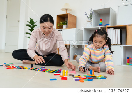 toddler girl and mother playing colorful wooden block toy or domino game together 132470207