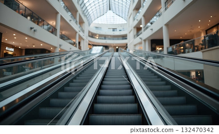 Modern Shopping Mall Interior with Escalators Leading to Upper Levels 132470342