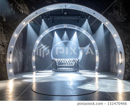 A futuristic silver show event space with a circular stage illuminated by spotlights 132470466