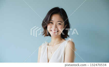 Smiling Woman with Short Hair against a Soft Blue Background Portrait Photography 132470534