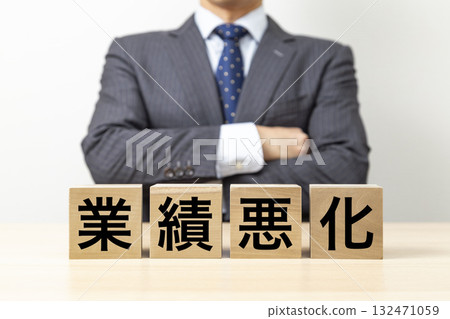 A businessman with his arms crossed and a block that reads "Deteriorating business performance" 132471059