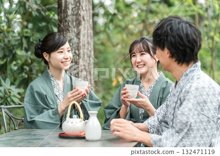 Traveling to a Ryokan/Hot Spring Inn, Young men and women on a company trip drinking tea on the terrace (travel) 132471119