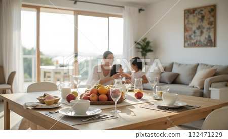 Family Enjoying Quality Time Together in Bright Modern Living Room with Fresh Fruits 132471229