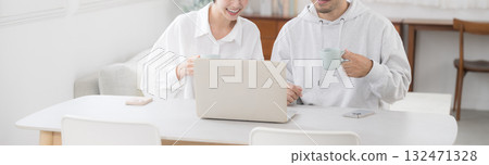 A couple talking while looking at a dining computer in a beautiful living room. An image of a happy marriage. Banner A couple talking while looking at a dining computer in a beautiful living room. An image of a happy marriage. Banner 132471328