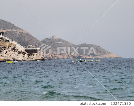 serene coastal scene, tranquil marine setting where cliffs meet turquoise waters and kayaks await 132471520