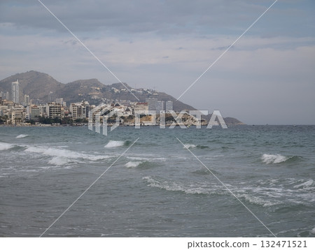 coastal cityscape overview, serene waterfront with skyline, quiet seaside promenade beneath cloudy 132471521