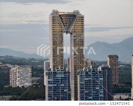 stylish building with angular glass facade overlooking city and surrounding natural landscape 132471541