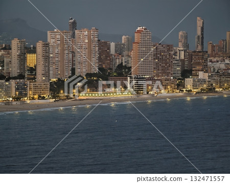 seaside cityscape view, nighttime coastal metropolis featuring illuminated walkways and ocean waves seaside cityscape view, nighttime coastal metropolis featuring illuminated walkways and ocean waves 132471557