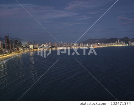 serene coastal view during sunset hours, relaxed dusk seaside scene with city lights and distant serene coastal view during sunset hours, relaxed dusk seaside scene with city lights and distant 132471574