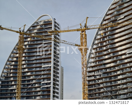 cityscape with rising towers, construction site scene showing cranes and scaffolding in city 132471817