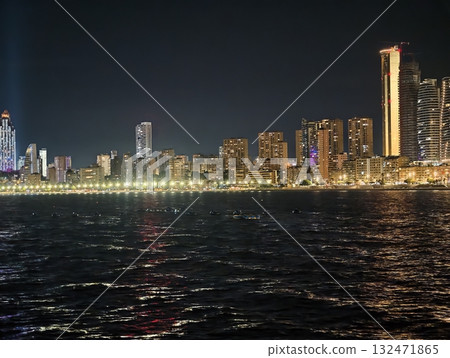 luminous skyline with diverse architecture reflected in tranquil waters during lively nocturnal 132471865