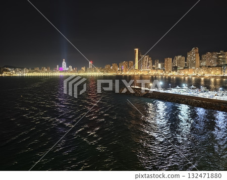 luminous skyline with diverse architecture reflected in tranquil waters during lively nocturnal 132471880