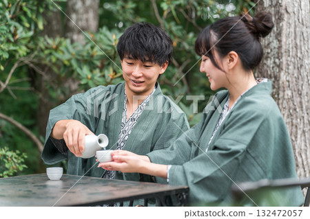 A couple in yukata drinking sake on the garden terrace of a traditional Japanese inn A couple in yukata drinking sake on the garden terrace of a traditional Japanese inn 132472057