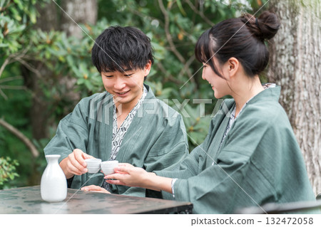 A couple in yukata drinking sake on the garden terrace of a traditional Japanese inn 132472058