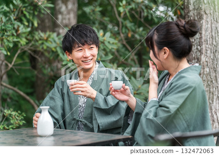 A couple in yukata drinking sake on the garden terrace of a traditional Japanese inn 132472063