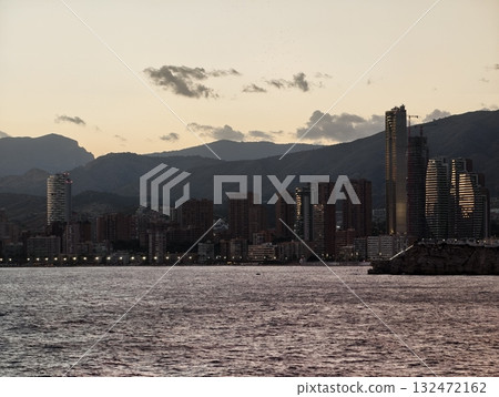 serene shoreline with distant peaks, calm coastal landscape with fading sunset and distant mountains serene shoreline with distant peaks, calm coastal landscape with fading sunset and distant mountains 132472162