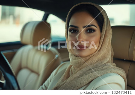 Arab businesswoman in luxury car, symbol of success and ambition, confident expression 132473411