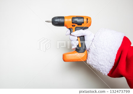 Santa's hands using an orange colored drill Santa's hands using an orange colored drill 132473799