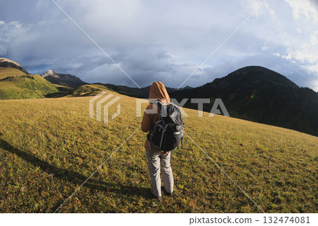 Woman backpacker hiking on high altitude mountains Woman backpacker hiking on high altitude mountains 132474081