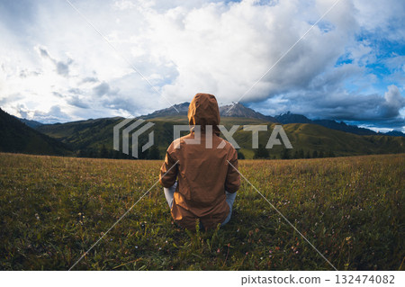 Woman hiker meditation on the high altitude mountain top grassland 132474082