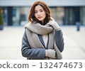 An urban woman wearing a gray coat and a thick scarf 132474673