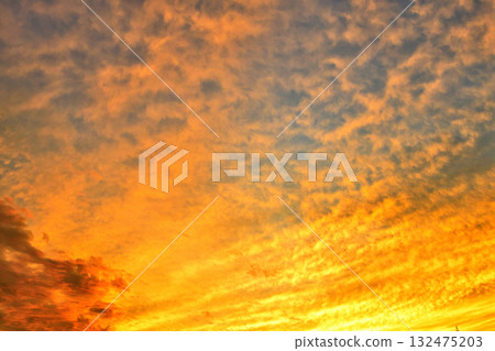 傍晚的天空中，橙色的雲朵呈現放射狀蔓延 132475203