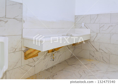 New restroom area sleek white sink on wooden base, emphasizing simplicity cleanliness. 132475540