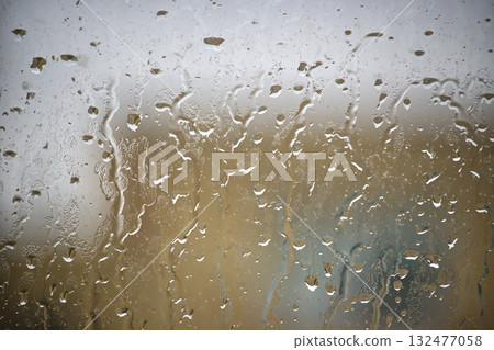 Condensation On Glass Window Creating Abstract Wet Surface With Blurred Indoor Scene Condensation On Glass Window Creating Abstract Wet Surface With Blurred Indoor Scene 132477058