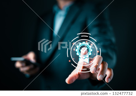 A businessman in a suit interacts with a glowing digital icon of a certificate featuring a checkmark, symbolizing quality assurance, certification, and trust in a modern digital environment. 132477732