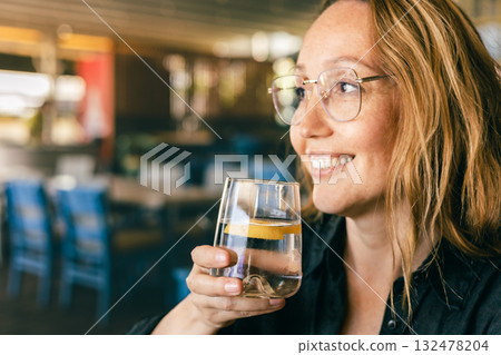 Happy Woman Drinking Water in Cafe, Healthy Lifestyle and Refreshment, Natural Light Close-Up 132478204