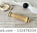 Foot care products: wooden rollers, black balls, and ballet shoes are placed on the shabby floor. 132478334
