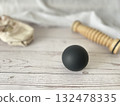 Foot care products: black balls, wooden rollers, and ballet shoes are placed on the shabby floor. 132478335