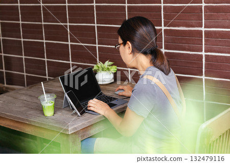 Asian woman cafe owner working with laptop outdoors. Asian woman cafe owner working with laptop outdoors. 132479116