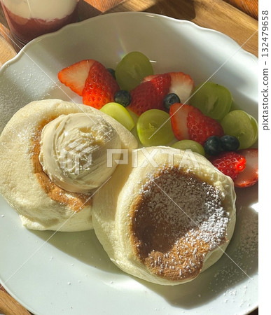 Fluffy soufflé pancake topped with airy cream, sweet banana slices, and juicy peaches, offering a perfect blend of soft texture and fruity sweetness in every dreamy, melt-in-your-mouth bite. Fluffy soufflé pancake topped with airy cream, sweet banana slices, and juicy peaches, offering a perfect blend of soft texture and fruity sweetness in every dreamy, melt-in-your-mouth bite. 132479658