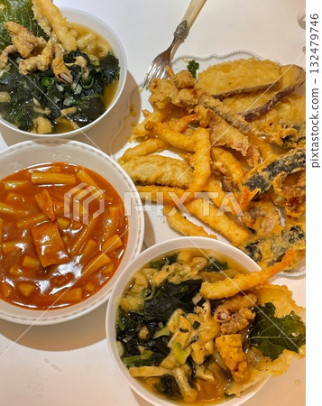 A variety of delicious Korean street food, bunsik includes snacks like tteokbokki, odeng, and hotteok, offering a flavorful mix of spicy, savory, and sweet tastes in every bite. A variety of delicious Korean street food, bunsik includes snacks like tteokbokki, odeng, and hotteok, offering a flavorful mix of spicy, savory, and sweet tastes in every bite. 132479746